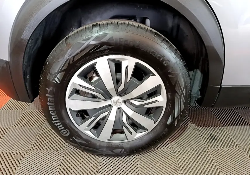 Gros plan sur la roue avant droite d’un Peugeot 2008 gris clair avec jante en alliage et pneu Continental.