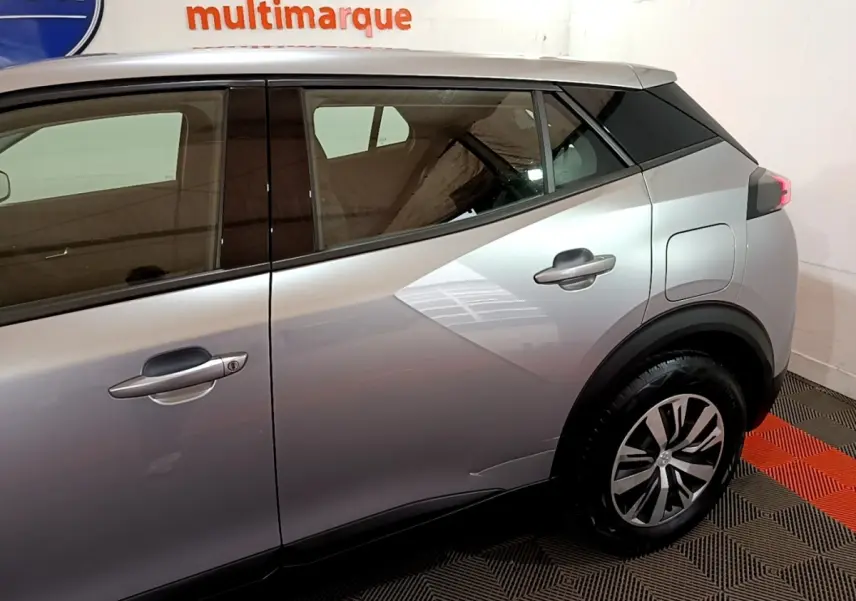 Vue côté droit arrière du Peugeot 2008 gris clair, mettant en valeur les lignes anguleuses et les jantes modernes.