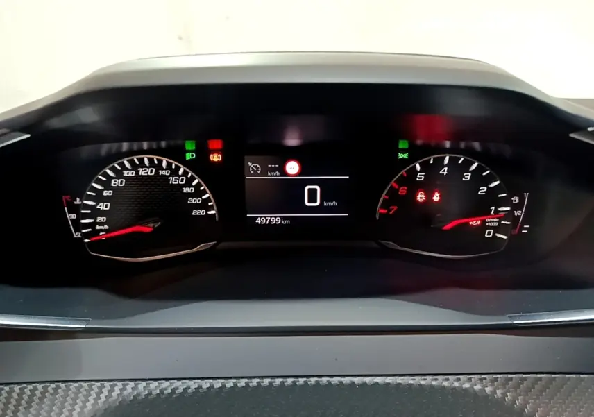 Vue rapprochée du tableau de bord numérique du Peugeot 2008 gris clair, affichant 0 km/h et 49 799 km au compteur.