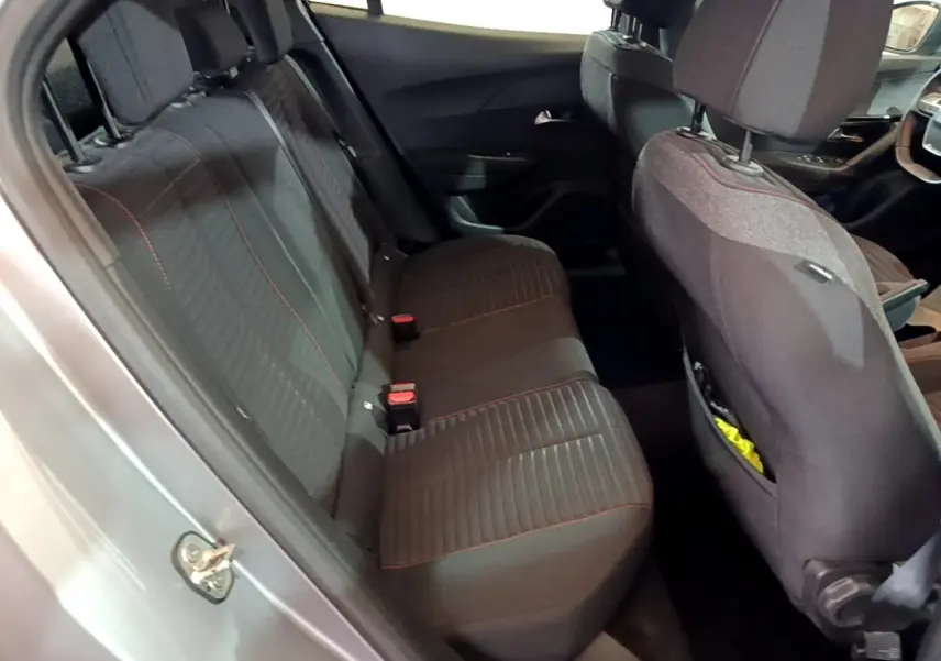 Vue intérieure côté gauche des sièges arrière noirs avec surpiqûres rouges dans un Peugeot 2008 gris clair de 2021.