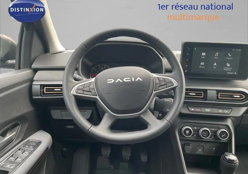 Vue frontale de l'intérieur du Dacia Sandero Stepway 2024, avec volant, tableau de bord et écran multimédia visible.