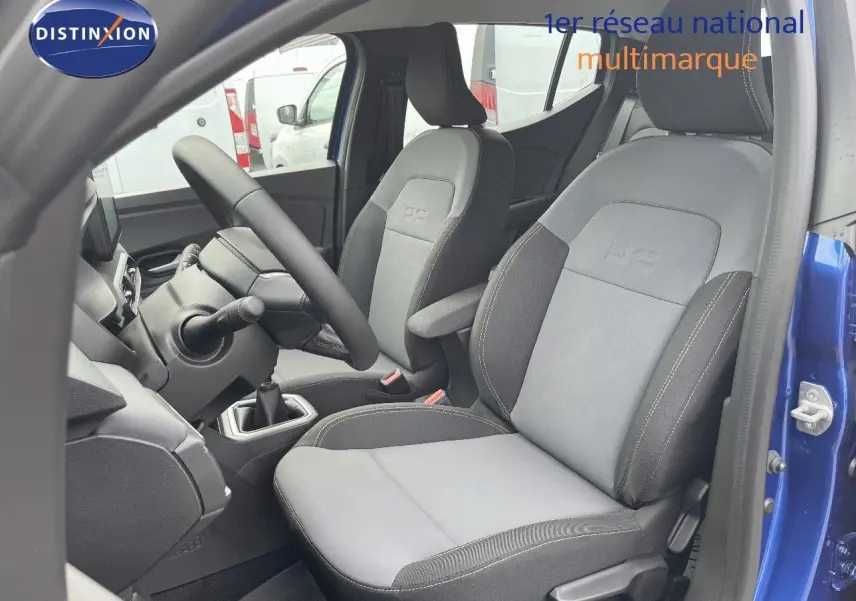 Vue intérieure côté conducteur de la Dacia Sandero Stepway 2024 bleu Iron Metal, sièges gris avec surpiqûres contrastées.