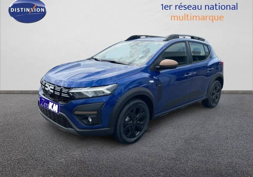 Vue 3/4 avant droite d'une Dacia Sandero Stepway 2024 bleu iron metal avec jantes noires et coques de rétroviseur beige.