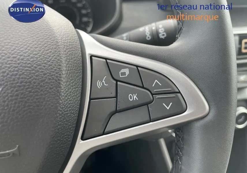 Gros plan sur les commandes multifonctions à droite du volant en cuir noir d'une Dacia Sandero Stepway 2024.