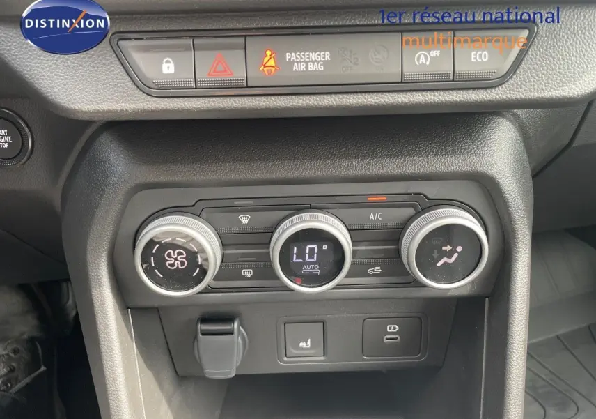 Vue rapprochée des commandes de climatisation et des boutons de sécurité du tableau de bord d'une Dacia Sandero Stepway 2024.