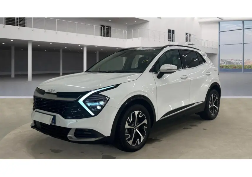 KIA SPORTAGE hybride blanc vue 3/4 avant avec toit noir et jantes alliage 18 pouces en intérieur showroom.