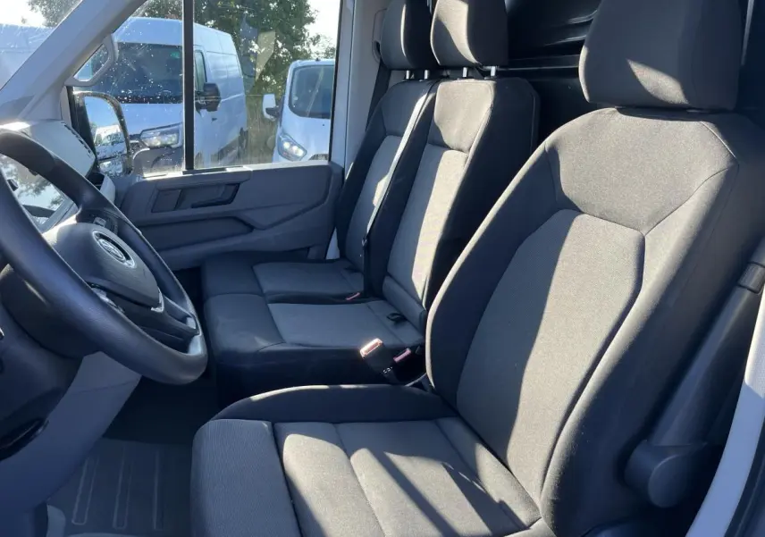 Intérieur du Volkswagen Crafter Fourgon 2022, vue côté conducteur sur banquette double en tissu gris foncé.