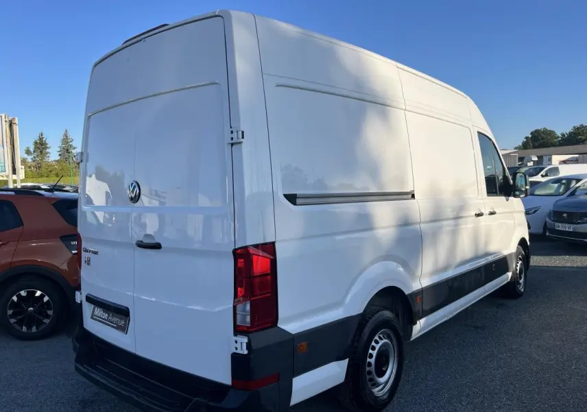 Volkswagen Crafter fourgon blanc vu en 3/4 arrière droit, portes battantes arrière fermées et jantes acier argentées.