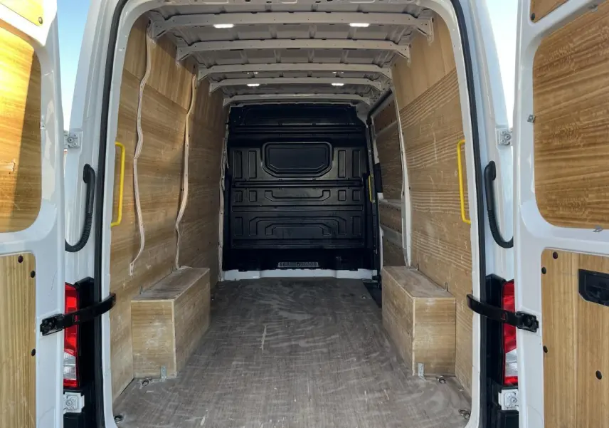 Vue arrière du Volkswagen Crafter blanc 2022, montrant l'espace de chargement avec plancher et parois en bois.