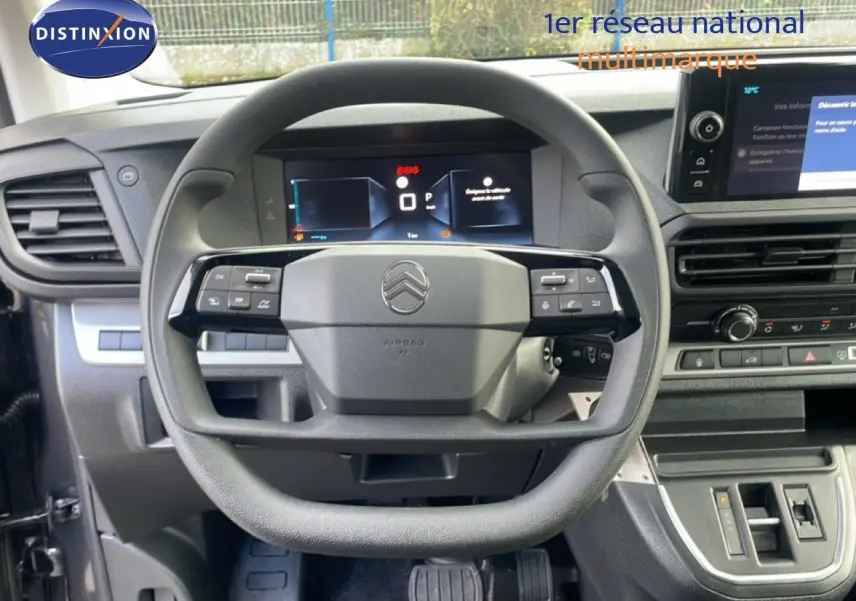 Vue rapprochée du volant multifonction et du tableau de bord numérique d'un Citroën Jumpy gris titane.