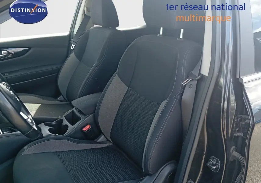 Vue intérieure côté conducteur du Nissan Qashqai noir métal 2018, mettant en valeur les sièges avant en tissu bicolore.