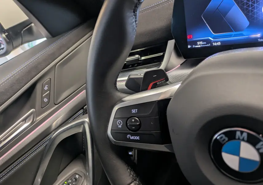 Vue intérieure côté conducteur du BMW X2 sDrive blanc alpin, sièges sport noirs en Alcantara et tableau de bord luxe visible.