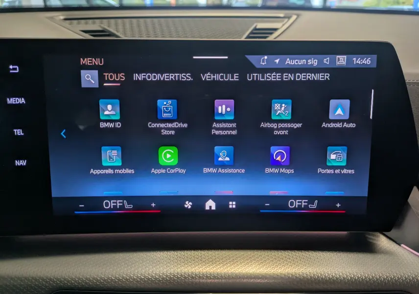 Tableau de bord numérique du BMW X2 sDrive blanc, affichant vitesse, consommation et état du véhicule en stationnement.