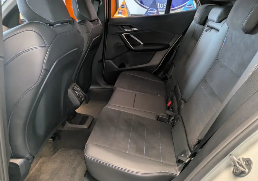 Écran tactile du système de navigation du BMW X2 sDrive blanc, affichant une carte et options de destination.