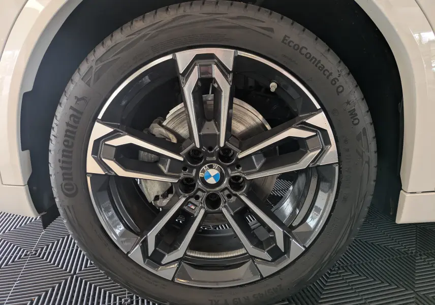 Gros plan sur la roue avant droite blanche alpin du BMW X2 sDrive M Sport 2025 avec jante noire et argentée distinctive.