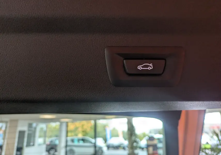Bouton de fermeture électrique du coffre sur le hayon intérieur d'un BMW X2 sDrive blanc alpin 2025.