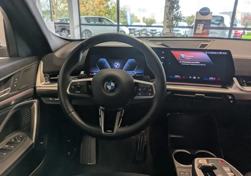 Gros plan sur les commandes de lève-vitres et rétroviseurs côté conducteur d'une BMW X2 sDrive blanc alpin.