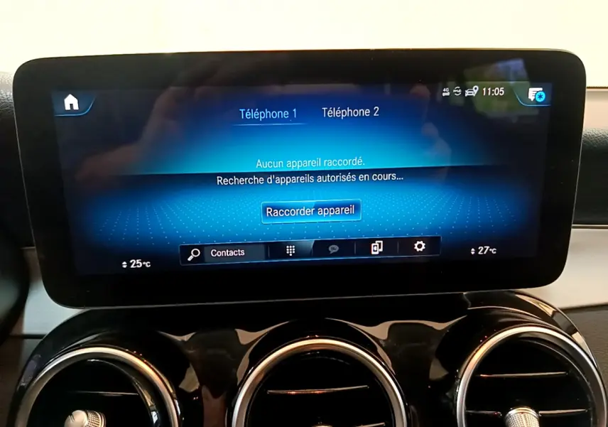 Écran tactile central affichant la connexion Bluetooth, entouré de trois aérateurs ronds chromés sur tableau de bord noir.