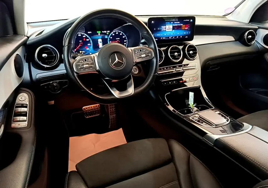 Intérieur avant de la Mercedes GLC 300 E AMG Line 2021, tableau de bord moderne avec écran tactile et volant cuir noir.