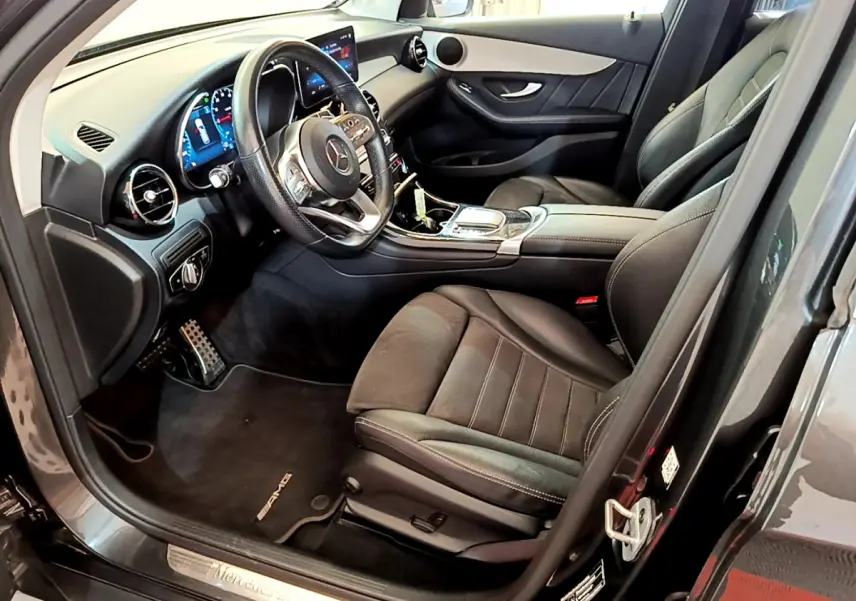 Intérieur côté conducteur du Mercedes GLC 300 E AMG Line 2021 gris foncé, avec volant cuir et tableau de bord numérique.