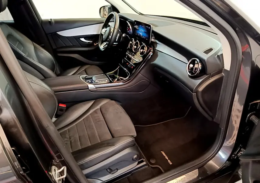 Intérieur côté conducteur du Mercedes GLC 300 E AMG Line 2021, sièges cuir noirs et tableau de bord moderne avec écran tactile.