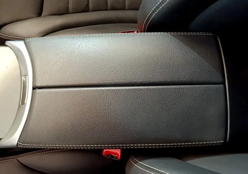 Accoudoir central en cuir noir avec surpiqûres blanches dans l'habitacle d'un Mercedes GLC 300 E AMG Line 2021.