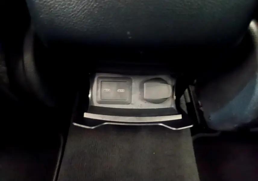 Prise USB et prise 12V en bas de la console centrale d'un Mercedes GLC 300 E AMG Line gris foncé 2021.