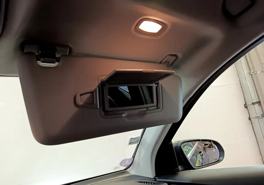 Miroir de courtoisie ouvert côté conducteur dans l'habitacle clair d'un Mercedes GLC 300 E AMG Line gris foncé 2021.