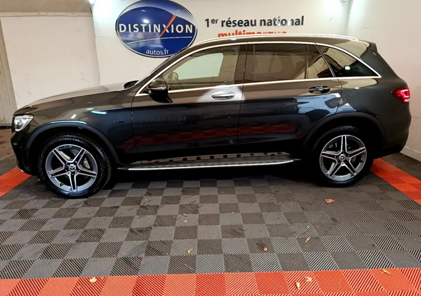 Profil côté gauche d'un Mercedes GLC 300 E AMG Line gris foncé avec jantes alliage et toit panoramique.