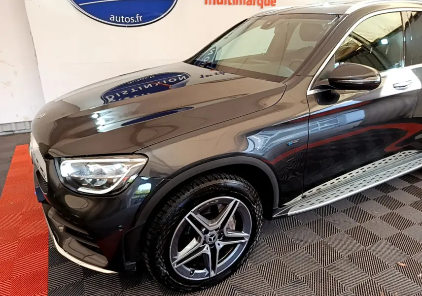 Vue 3/4 avant droit d'un Mercedes GLC 300 E AMG Line gris foncé avec jantes alliage et badge hybride rechargeable.