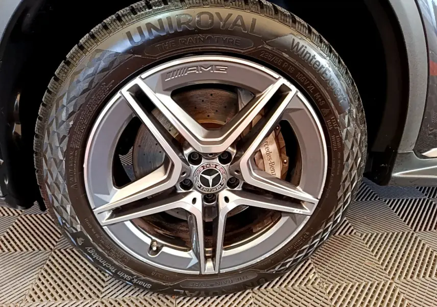 Gros plan sur la roue avant droite AMG du Mercedes GLC 300 E AMG Line gris foncé avec pneu Uniroyal hiver.