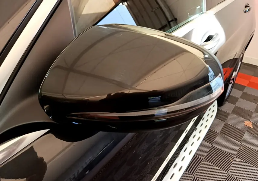 Rétroviseur droit noir brillant du Mercedes GLC 300 E AMG Line 4MATIC gris foncé, vue rapprochée en intérieur.