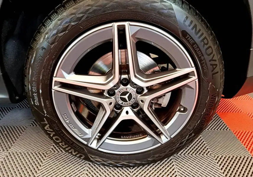 Gros plan sur la jante AMG étoile grise et pneu Uniroyal du Mercedes GLC 300 E AMG Line hybride rechargeable.