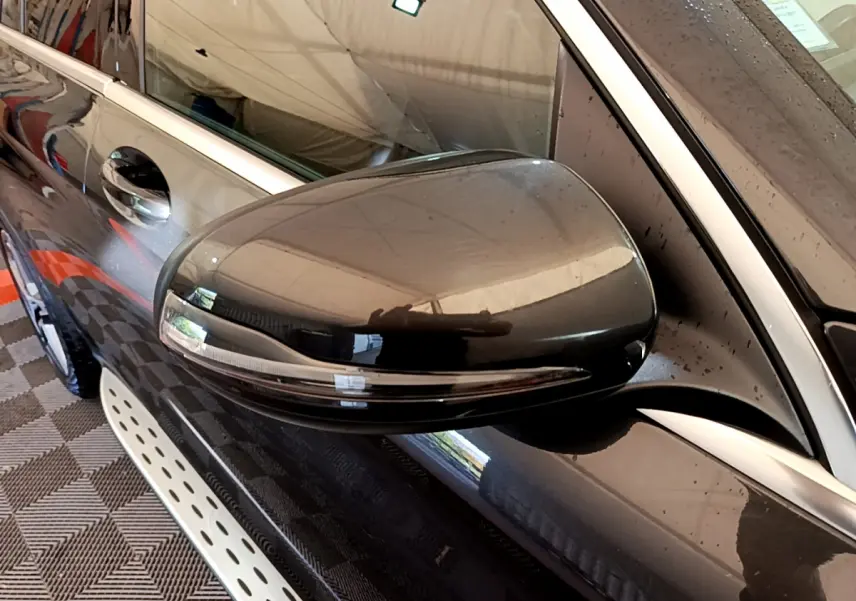 Rétroviseur côté gauche gris foncé du Mercedes GLC 300 E AMG Line 4MATIC avec clignotant intégré, vue rapprochée.