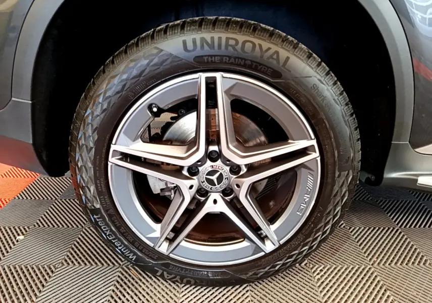 Gros plan sur la roue avant droite gris foncé d'un Mercedes GLC 300 E AMG Line avec jante AMG cinq branches.