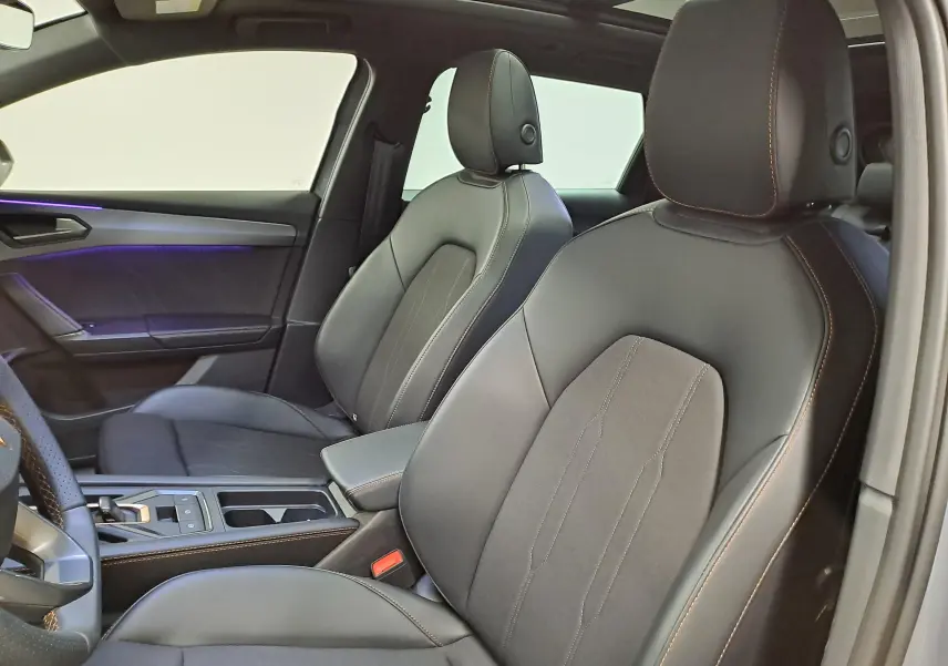 Vue intérieure côté droit de la CUPRA LEON ST 2025, sièges en cuir noir avec surpiqûres cuivrées et toit ouvrant panoramique.