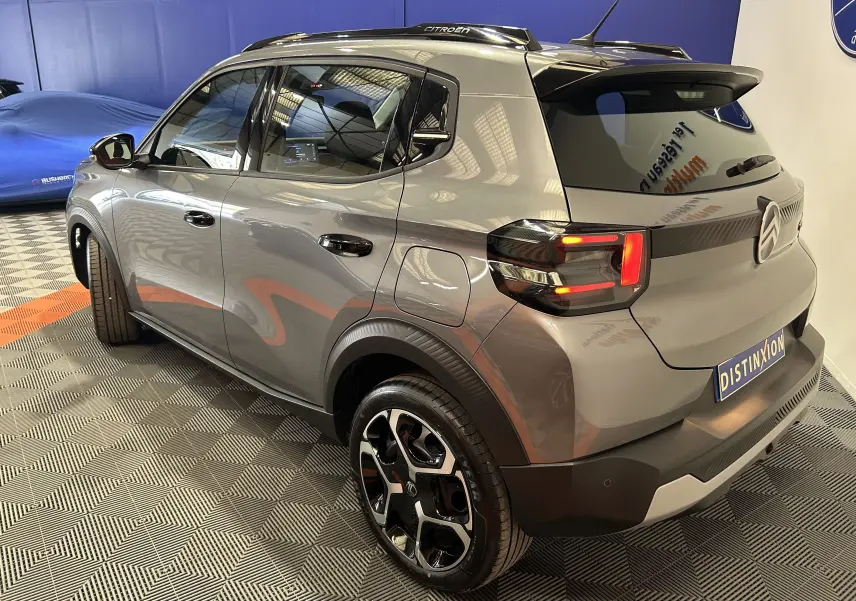 Vue 3/4 arrière droite d'une Citroën C3 2025 gris Artense avec feux LED et jantes noires bicolores.