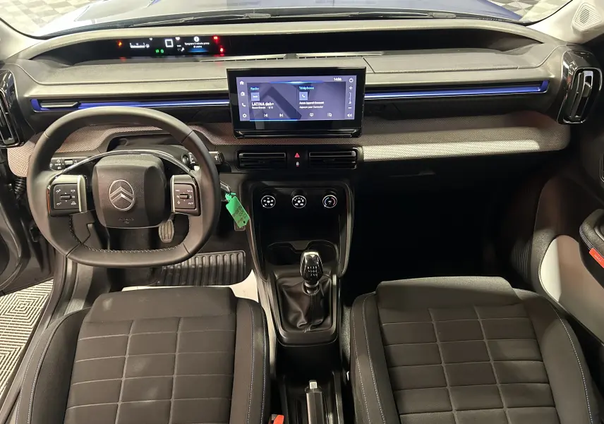 Vue intérieure frontale de la Citroën C3 Turbo 100 Plus gris Artense, avec tableau de bord moderne et écran tactile central.