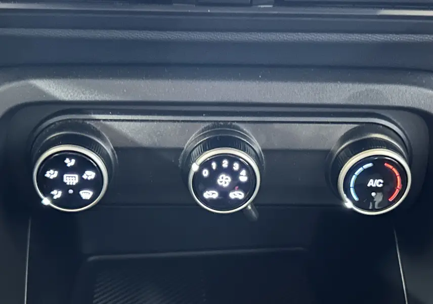 Gros plan sur les commandes de climatisation manuelle de la Citroën C3 Turbo 100 Plus, avec réglages éclairés.