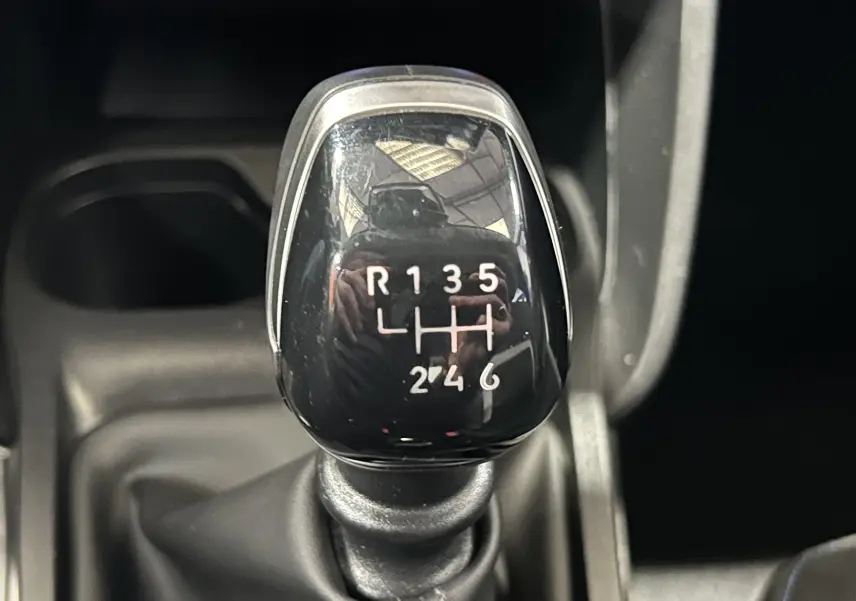 Gros plan sur le levier de vitesses manuel noir de la Citroën C3 Turbo 100 Plus Gris Artense, avec marquage des 6 rapports et marche arrière.