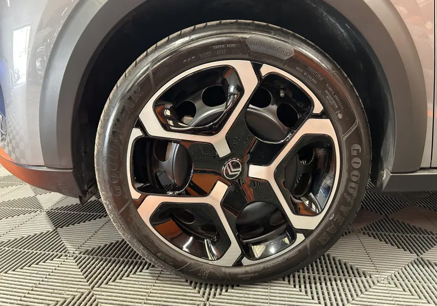 Gros plan sur la roue avant droite de la Citroën C3 gris Artense, avec jante alliage noire et argentée au design moderne.