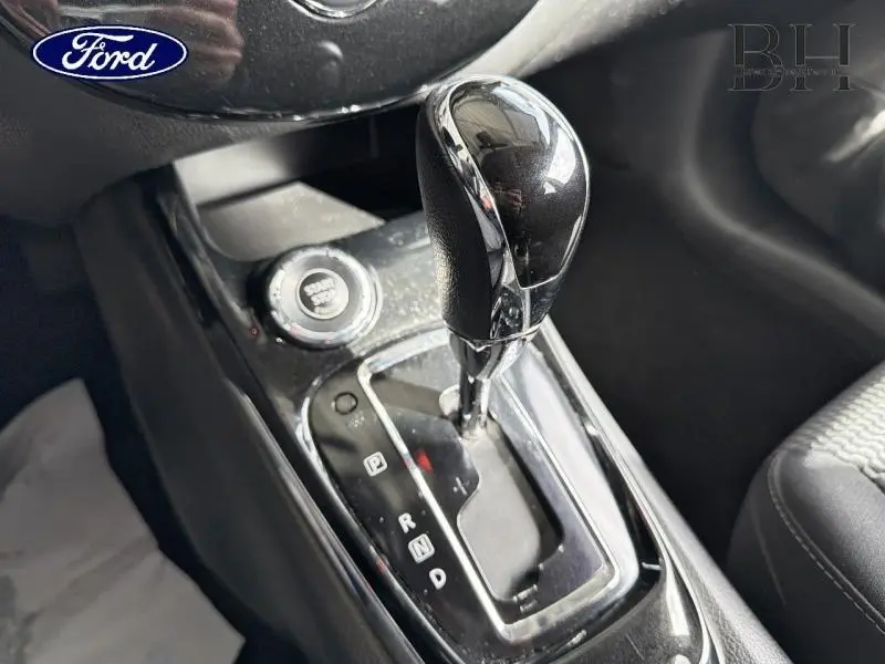 Gros plan sur le levier de vitesses automatique noir et chrome de la Nissan Pulsar bronze ultime, avec bouton start visible.