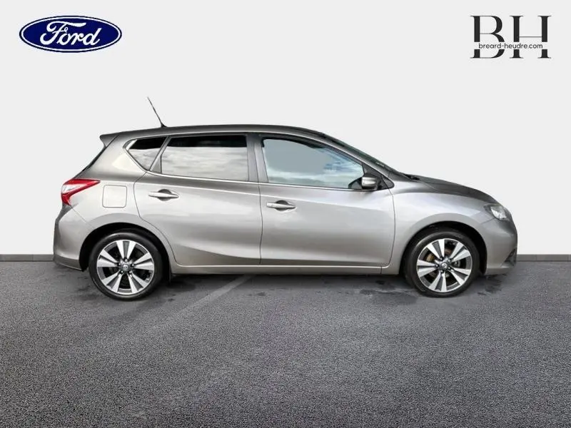 Profil côté gauche d'une Nissan Pulsar 2017 gris métallisé avec jantes alliage et vitres teintées.