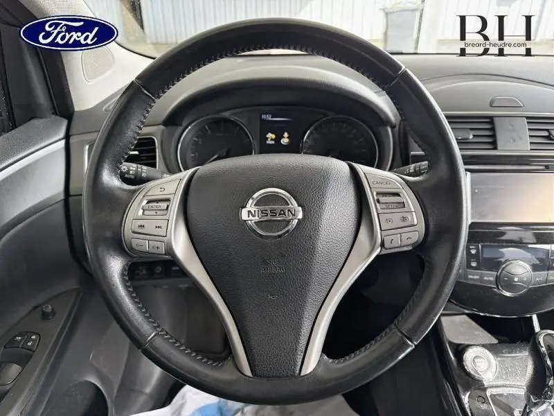 Vue intérieure centrée sur le volant cuir noir de la Nissan Pulsar 1.2 DIG-T 115ch avec commandes multifonctions.