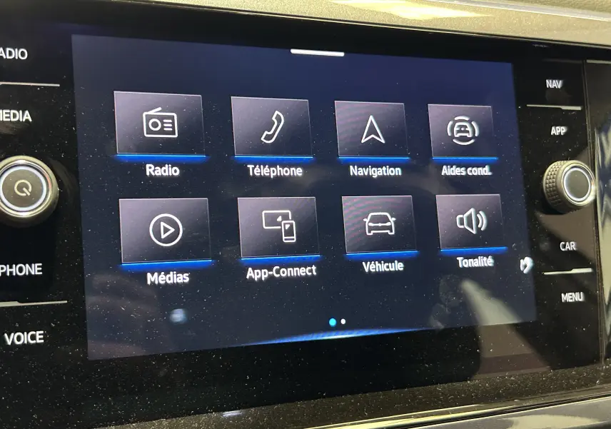 Écran tactile central du Volkswagen Taigo TSI 110 DSG7 Style 2022 affichant les menus radio, téléphone, navigation et aides à la conduite.