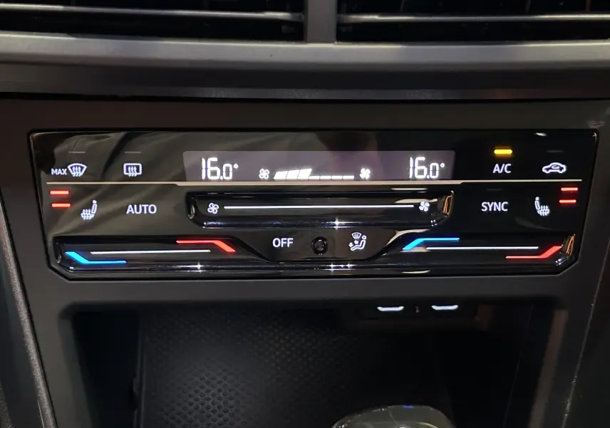 Panneau de commande de la climatisation digitale du Volkswagen Taigo blanc, affichant 16°C et réglages chauffants et ventilés.