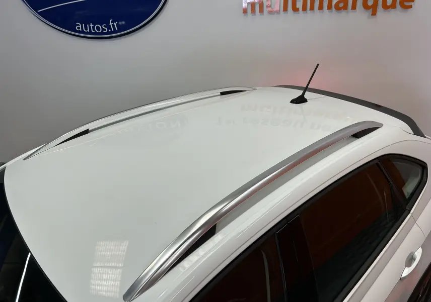 Toit blanc pur de Volkswagen Taigo TSI 110 DSG7 Style vu en léger angle, avec barres de toit argentées et antenne noire.