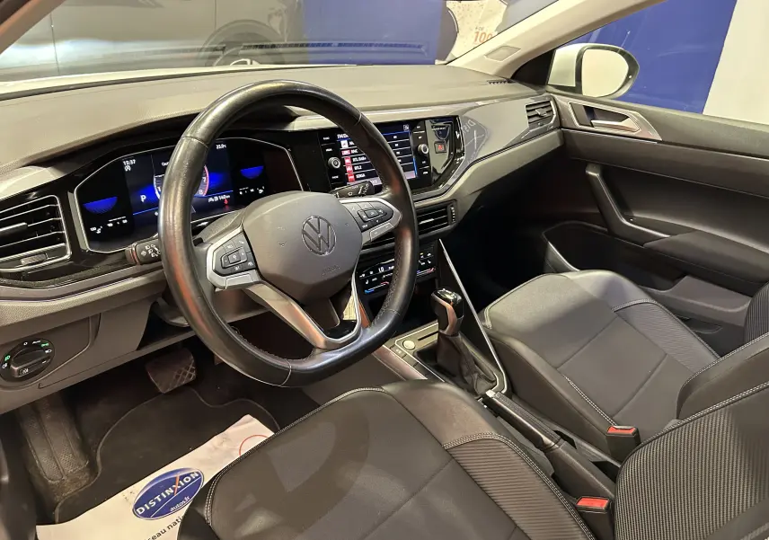Intérieur avant droit du Volkswagen Taigo TSI 110 DSG7 Style 2022, tableau de bord numérique et sièges noirs.
