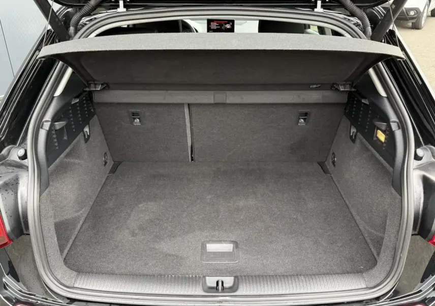 Coffre ouvert en vue arrière d'un Audi Q2 35 TFSI S-Line noir Mythe avec hayon électrique et plancher plat.