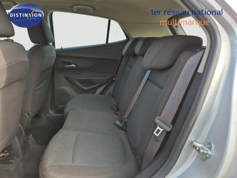Vue intérieure côté droit sur la banquette arrière noire d'un Opel Mokka X gris minéral avec ceintures de sécurité visibles.